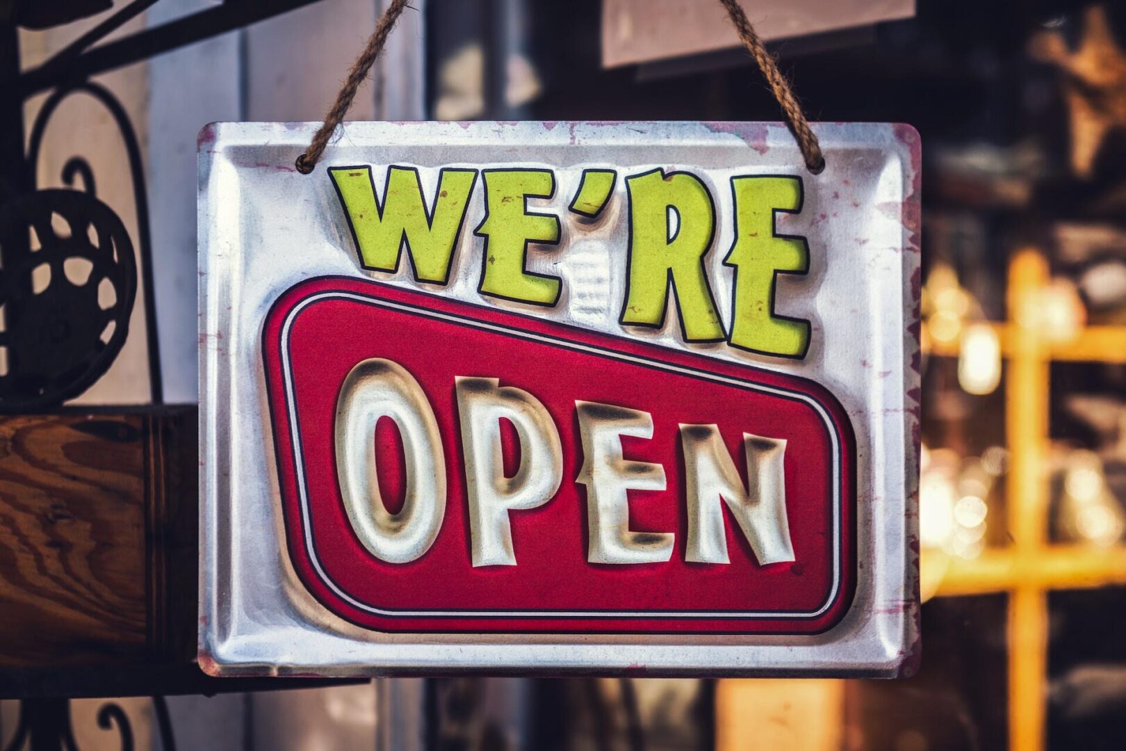 Colorful 'we're open' sign hanging at the entrance of a welcoming sole proprietorship establishment.