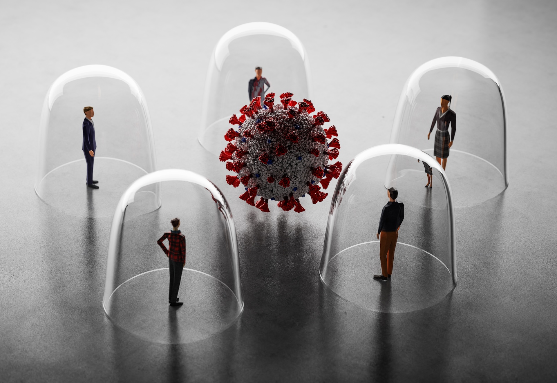 Several small human figurines stand under inverted glass cups, surrounding a large model of a coronavirus particle. The setup visually represents isolation and social distancing during the COVID-19 pandemic.