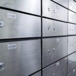 A close-up view of rows of metal safety deposit boxes with numbered labels and keyholes, arranged neatly in a secure bank vault—a trusted space for safeguarding assets as you explore Business Tax Relief Options for 2025.