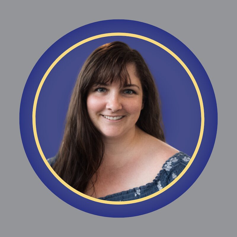 Portrait of a woman with long brown hair and bangs, smiling, wearing an off-the-shoulder blue floral top. The photo is set against a blue background with a circular yellow border and a gray outer area. Portrait of a woman with long brown hair and bangs, smiling, wearing an off-the-shoulder blue floral top. The photo is set against a blue background with a circular yellow border and a gray outer area.