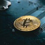 A gold Bitcoin coin rests on a dark computer circuit board, symbolizing cryptocurrency, digital finance technology, and the future of Crypto Tax Reporting 2026.