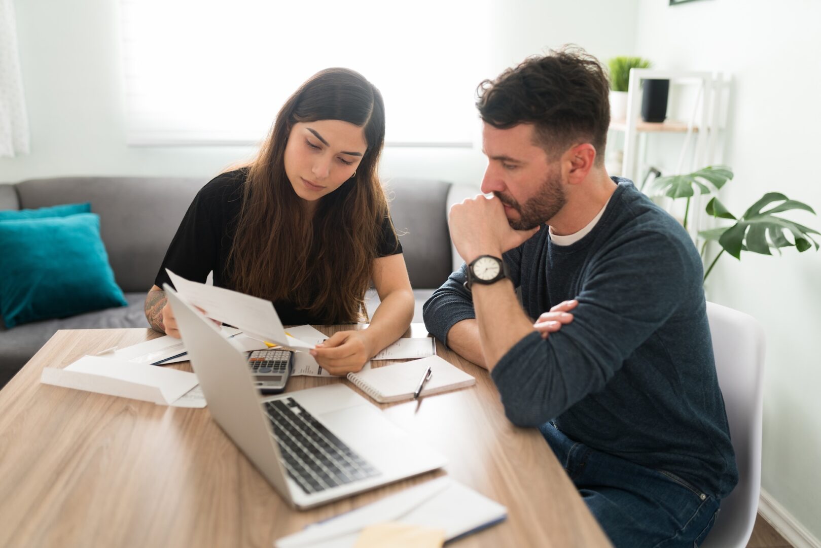 Couple reviewing IRS tax debt notices and financial records before choosing a resolution option Couple reviewing IRS tax debt notices and financial records before choosing a resolution option