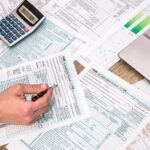 Business owner comparing federal and state tax returns for OBBBA conformity differences